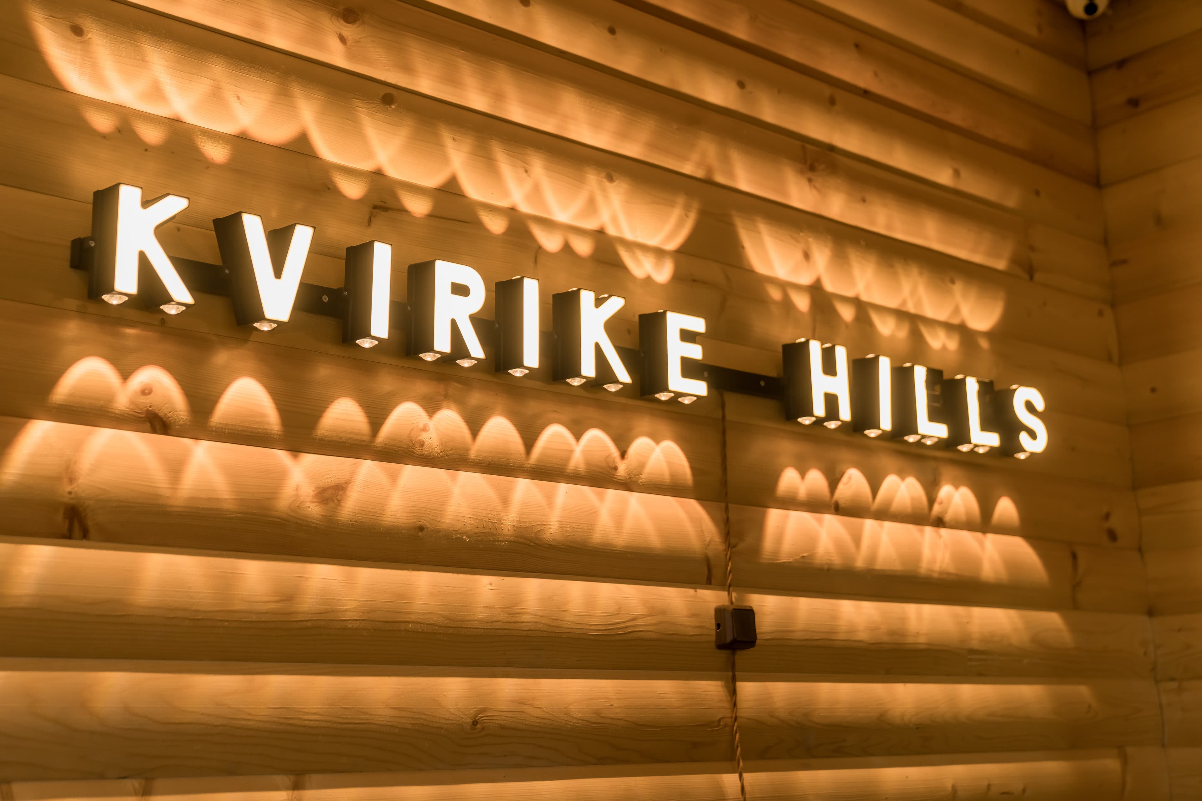 KVIRIKE HILLS backlit sign with freshly grilled shashlik in the foreground